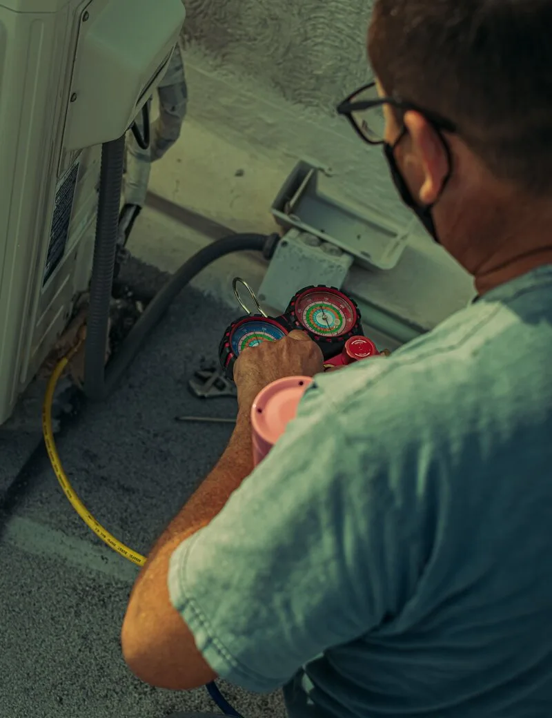 Technician servicing an outdoor air conditioning unit