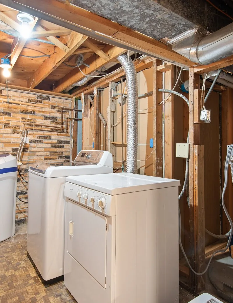 Residential laundry room with exposed dryer vent ducting